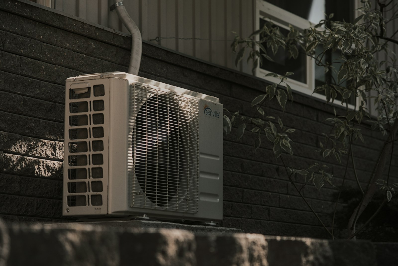 Unidad exterior de aire acondicionado en la fachada de una vivienda